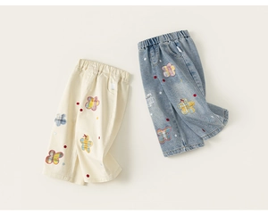 Detalle de pantalones de algodón para niños con motivos bordados de flores a cuadros