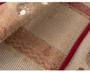 Detail of knitted children's set showing soft caramel fabric with embroidery and ribbed hem