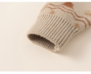 Close-up of knit sweater cuffs featuring beige and caramel holiday jacquard patterns