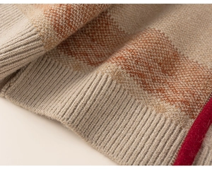 Detail of beige and brown striped knit sweater with red edge and soft ribbed texture