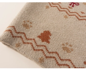 Detailed macro shot of knit fabric texture with brown paw prints and wave patterns