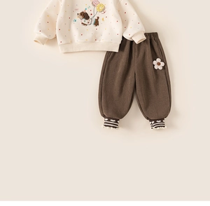 Detail of cream toddler sweatshirt with puppy print and brown pants with 3D floral accent