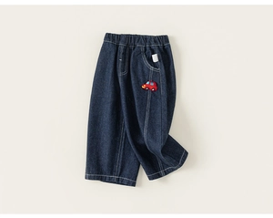 Detailed view of kids dark blue denim jeans with elastic waist and car patch embroidery