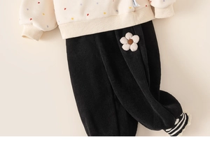 Detail of baby girl fleece sweatshirt with heart print and corduroy floral pants