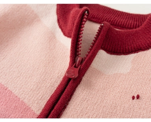 Detailed close-up of pink striped knit sweater with zipper and ribbed collar texture