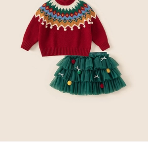 Détail d'un pull de Noël rouge avec col jacquard festif et jupe tutu en maille verte