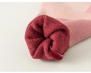 Close-up of knit fabric texture on a soft pink and dark red ribbed sleeve cuff