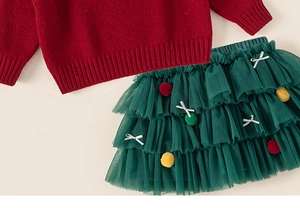 Détail du pull en tricot rouge et jupe en tulle vert forêt à volants pour petites filles