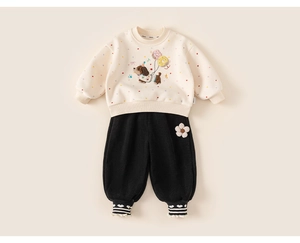 Detailed embroidery of dog and colorful balloons on cream-colored fleece sweatshirt
