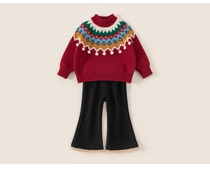 Détail d'un pull en tricot rouge à motif bohème et d'un pantalon évasé noir pour filles