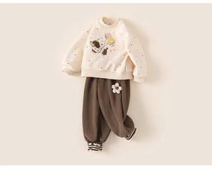 Detailed view of kids sweatshirt with heart prints and brown pants with flower applique
