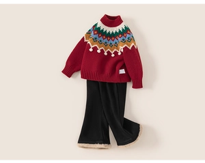 Détail d'un pull en maille rouge festif avec motif Fair Isle et pantalon bordé