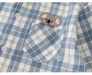 Detail of blue plaid shirt featuring high-quality cotton fabric and a cute koala embroidery