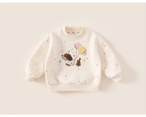 Detail of cream sweatshirt featuring puppy embroidery and warm ribbed knit cuffs