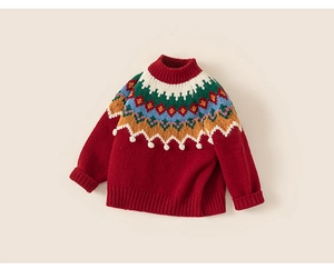 Détail d'un pull rouge enfant avec motif Fair Isle et petites boules en peluche