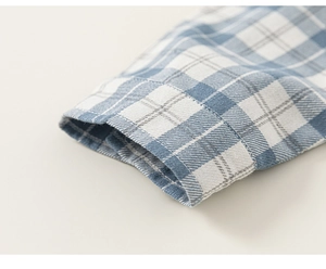Close-up of sleeve cuff on a blue and white checkered cotton shirt for children