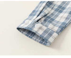 Detail of classic blue and white plaid shirt cuff with white button and neat stitching