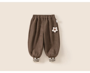 Détail du pantalon en velours côtelé marron fille avec écusson fleur et dentelle