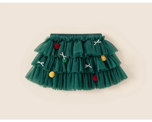 Détail d'une jupe tutu verte à volants avec pompons colorés et nœuds argentés