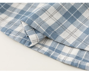 Detail of blue and white checkered cotton fabric with high-quality stitching and texture