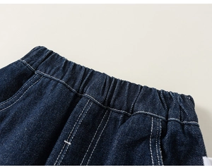 Detail of dark blue toddler jeans featuring elastic waistband with white stitching