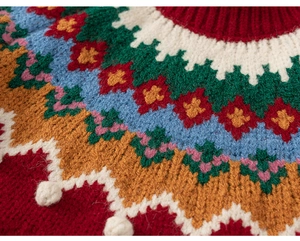 Zoom sur les détails du pull en tricot à motif nordique coloré avec pompons