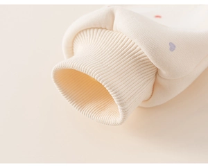 Close-up of elastic ribbed cuffs and heart print on girls' thick fleece sweatshirt