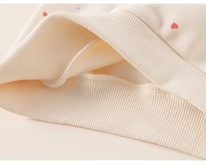 Detail of baby girl fleece sweatshirt showing ribbed cuffs and heart print texture