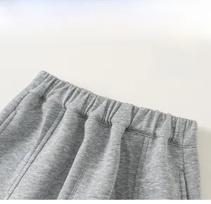 Détail de la taille élastique et des coutures de poche sur le jogging gris en coton