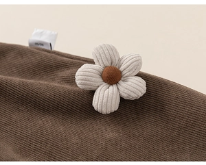 Détail du tricot côtelé marron café avec fleur 3D en velours et étiquette de soin