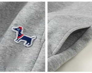 Détail du teckel brodé et des poches latérales sur ce pantalon en maille grise