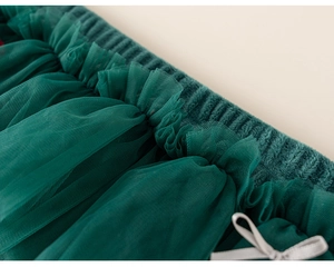 Détail de la jupe en tulle vert foncé avec taille élastique et noeud en ruban gris satiné