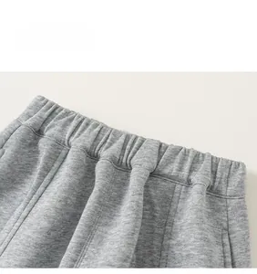 Détail de la taille élastique et texture du tissu en maille grise du pantalon enfant
