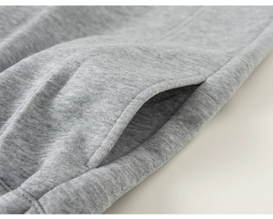 Détail des coutures de la poche latérale et de la maille gris chiné du sweat pour garçon