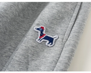 Détail macro du patch de teckel brodé sur le sweat-shirt en maille de coton gris chiné