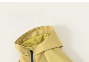 Détail de la veste coupe-vent jaune pour enfant avec zip bleu marine et capuche