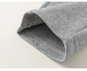 Détail du tissu en maille gris chiné montrant une double couture de qualité aux poignets