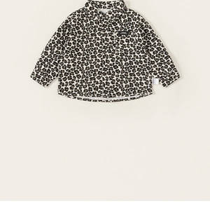 Detail of trendy leopard print boys' long-sleeved shirt with front pocket and button closure
