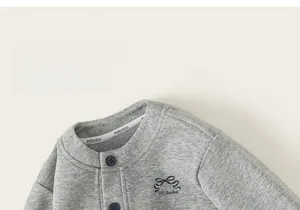 Detail view of gray knit toddler jacket with bow embroidery and button closure