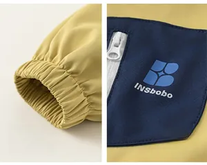 Détails des poignets élastiques et poches zippées sur ce coupe-vent jaune pour enfant