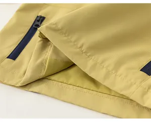 Vue détaillée de l'ourlet de la veste d'extérieur jaune moutarde avec poche zippée