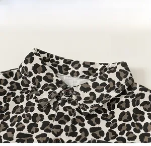 Detailed view of children's leopard print shirt featuring a classic collar and brown button