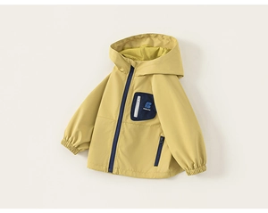 Détail du coupe-vent jaune enfant avec zip bleu contrasté et poche poitrine de marque