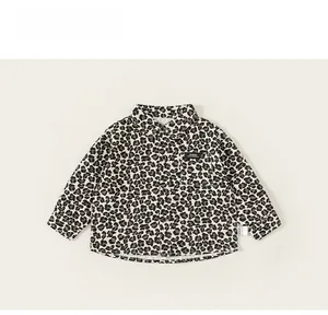 Detail of boys leopard print shirt showing collar, chest pocket and button structure