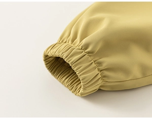 Détail du poignet élastique coupe-vent et texture du tissu sergé sur la veste pour enfant