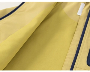 Vue macro d'une veste jaune moutarde montrant la doublure polaire et la fermeture éclair bleue