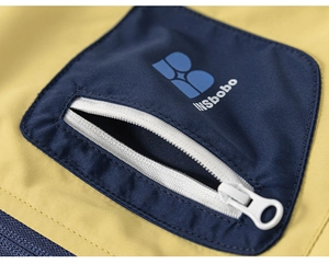 Vue macro de la poche de veste avec fermeture éclair blanche et logo bleu INSbobo