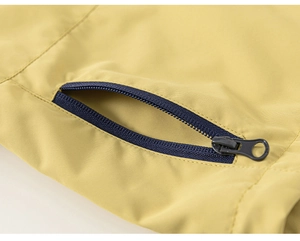 Détail du tissu coupe-vent et de la poche zippée bleu foncé sur veste outdoor pour enfants