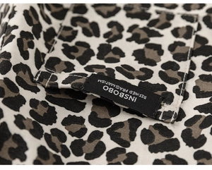 Detail of leopard print shirt featuring a stitched chest pocket and refined brand woven label