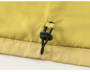 Détail de l'ourlet à cordon de serrage ajustable avec stoppeur noir sur une veste jaune